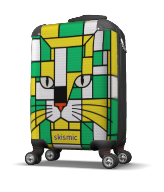 A hard-shell kids suitcase with a colorful geometric cat face print in green, yellow, white, and black, featuring the brand name 'skismic' near the bottom, shown on a white background.