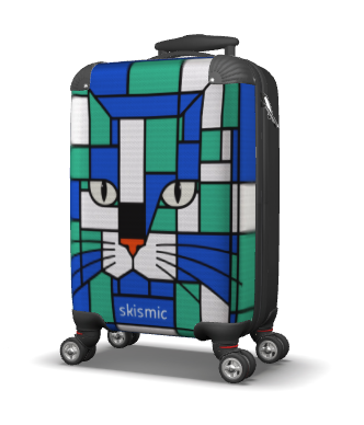 A hard-shell spinner suitcase with a colorful geometric cat-face print in blue, green, white, and black, featuring the brand name 'skismic' near the bottom.