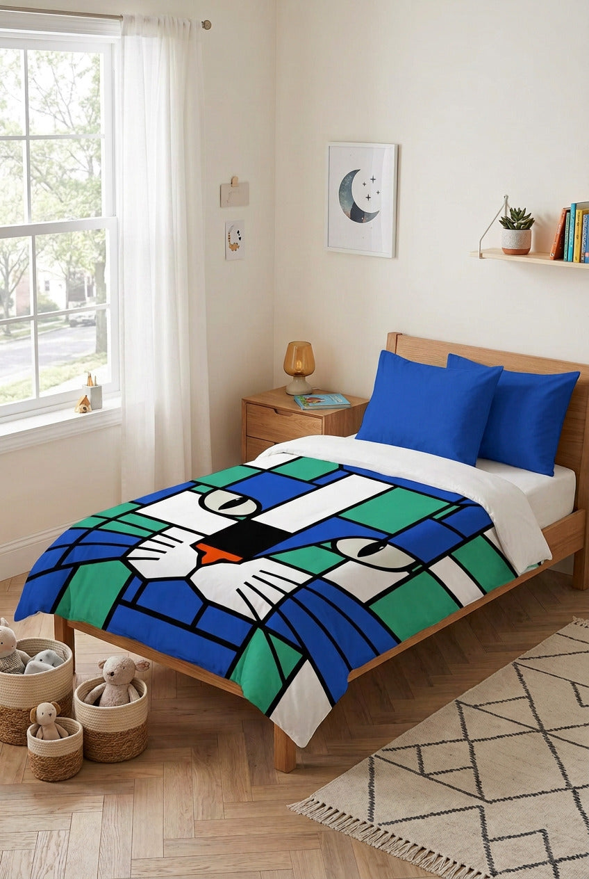 A kids duvet cover  featuring a stylized cat face in a stained-glass mosaic pattern with blue, green, white, with plain royal blue pillows